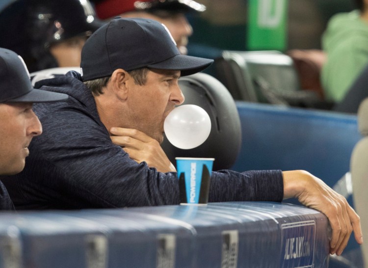 New York Yankees manager Aaron Boone blows a bubble with chewing gum in the sixth inning of a baseball game against the Toronto Blue Jays in Toronto, Friday, March 30, 2018. (Fred Thornhill/The Canadian Press via AP)