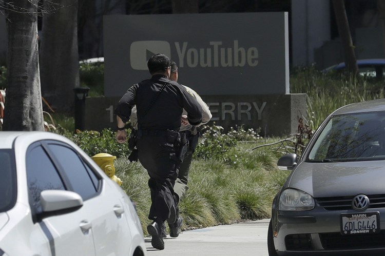 Officers run toward a YouTube office in San Bruno, Calif., on Tuesday. Police said they were responding to an active shooter there.