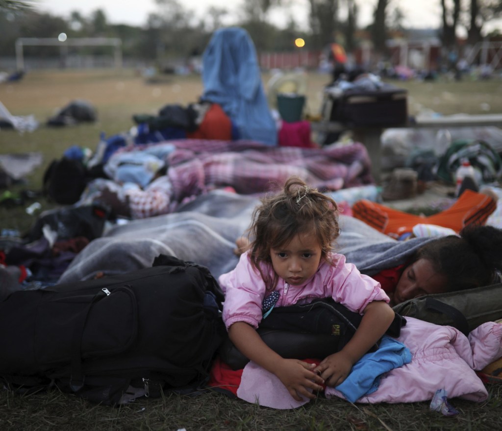 A girl remains awake as Central American migrants traveling with the annual "Stations of the Cross" caravan sleep at a sports club in Matias Romero, Mexico, on Tuesday.