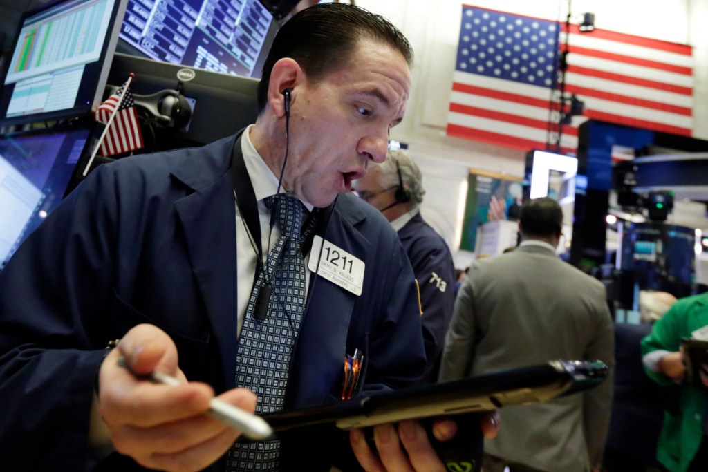 Trader Tommy Kalikas works the floor in New York early Wednesday, when China's retaliation for new U.S. tariffs sent stocks plunging. But the Dow ended up rising 231 points for the day.