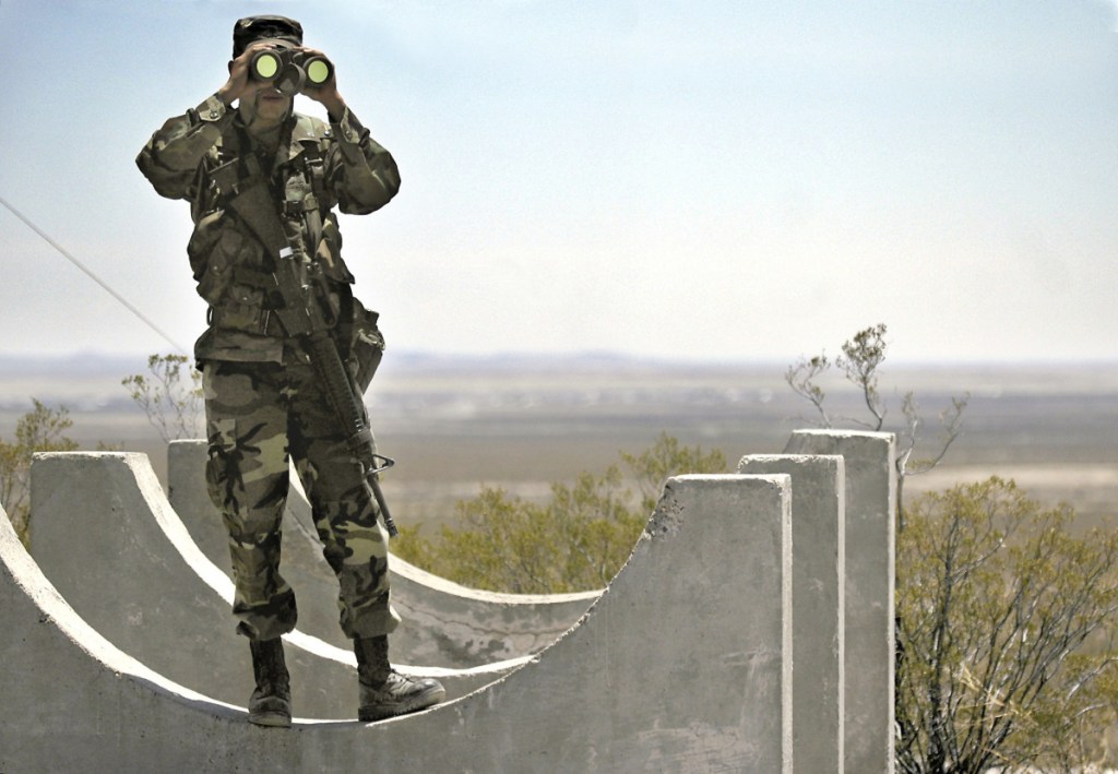 Army National Guard Spc. Gustavo Gutierrez, 23, of Las Cruces, N.M., scans the U.S./Mexico border from the top of Radar Hill, near Columbus, N.M., in June 2006.