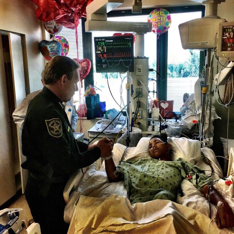 Broward County Sheriff Scott Israel holds the hand of 15-year-old Parkland survivor Anthony Borges on Feb. 18.