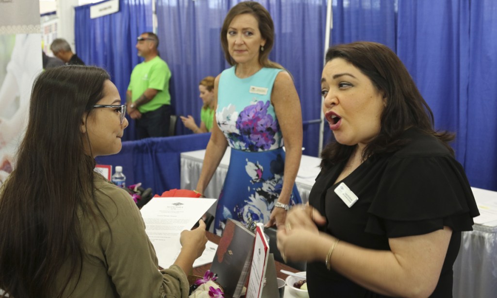 At a job fair in Honolulu in March, an employer speaks to a potential employee. The labor demand is driven by the state's tourism surge, but service jobs generally are low paying.