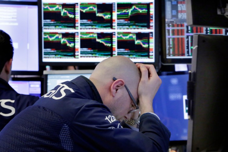 Specialist Mario Picone works at his post on the floor of the New York Stock Exchange on Friday as trade tensions with China were driving stocks down.