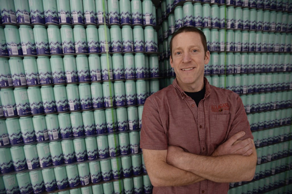 Allagash brewmaster Jason Perkins stands near a stack of 16-ounce cans that will soon be filled with Hoppy Table Beer as the Portland company – and Maine's largest brewery – tests out a container other than bottles. Canning is "something we're excited to learn more about," he said. Now just two of the state's 10 largest breweries sell their beer only in a bottle.