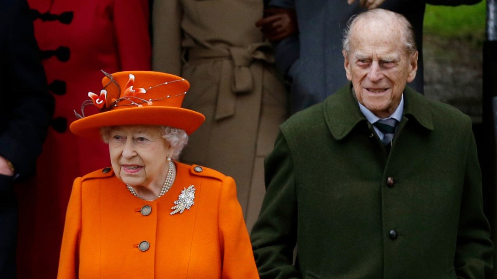 Queen Elizabeth II and Prince Philip wait for their car after a Christmas Day church service in Sandringham, England.