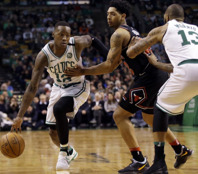 Terry Rozier of the Boston Celtics finds room to drive against Cameron Payne of the Chicago Bulls as Marcus Morris of Boston sets a pick in the first half Friday night.