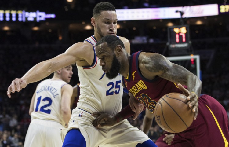 LeBron James of the Cleveland Cavaliers drives to the basket Friday night against Ben Simmons of the Philadelphia 76ers during the first half of Philadelphia's 132-130 victory – its 13th straight.