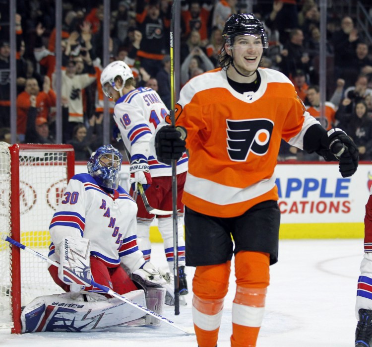 Nolan Patrick of the Philadelphia Flyers smiles Saturday while skating to congratulate Claude Giroux, who scored during the second period of a 5-0 victory against the New York Rangers. Giroux finished with three goals.