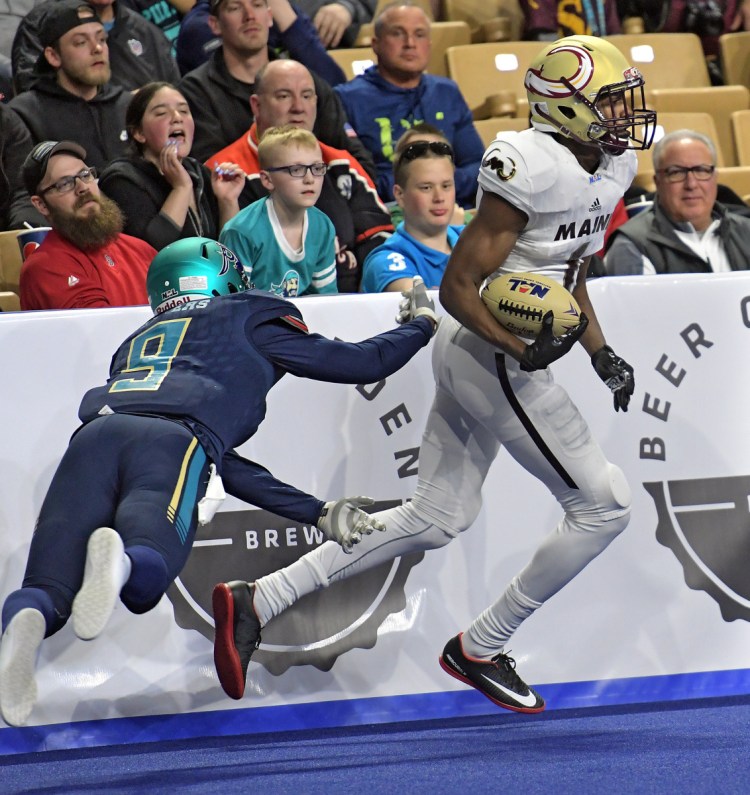 Maine's Derrick Macon eludes the tackle attempt of Massachusetts' Troy Sanders at the DCU Center during the first game in National Arena League history for both teams on Saturday in Worcester, Massachusetts. The Pirates won 51-24.