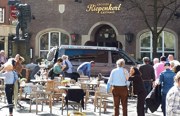 People react in front of a popular bar Saturday in Muenster, Germany, where a van crashed into a group of people, killing two and injuring 20. The driver shot himself to death inside the van.