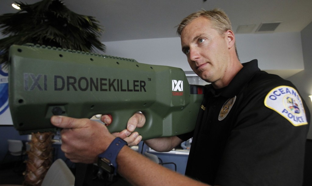 Oceanside Police Officer Mark Bussey aims the "drone killer," which brings a drone back to the ground by hitting it with radio waves that break the connection.