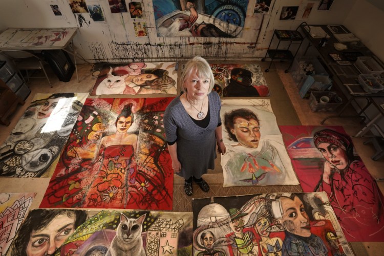Martha Miller poses for a photo with paintings from her current project, the "Lisbeth Series," in her studio in Woolwich. Over the past several weeks, Miller has been creating highly graphic, sometimes disturbing and sometimes beautiful images of her daughter, who is disabled.