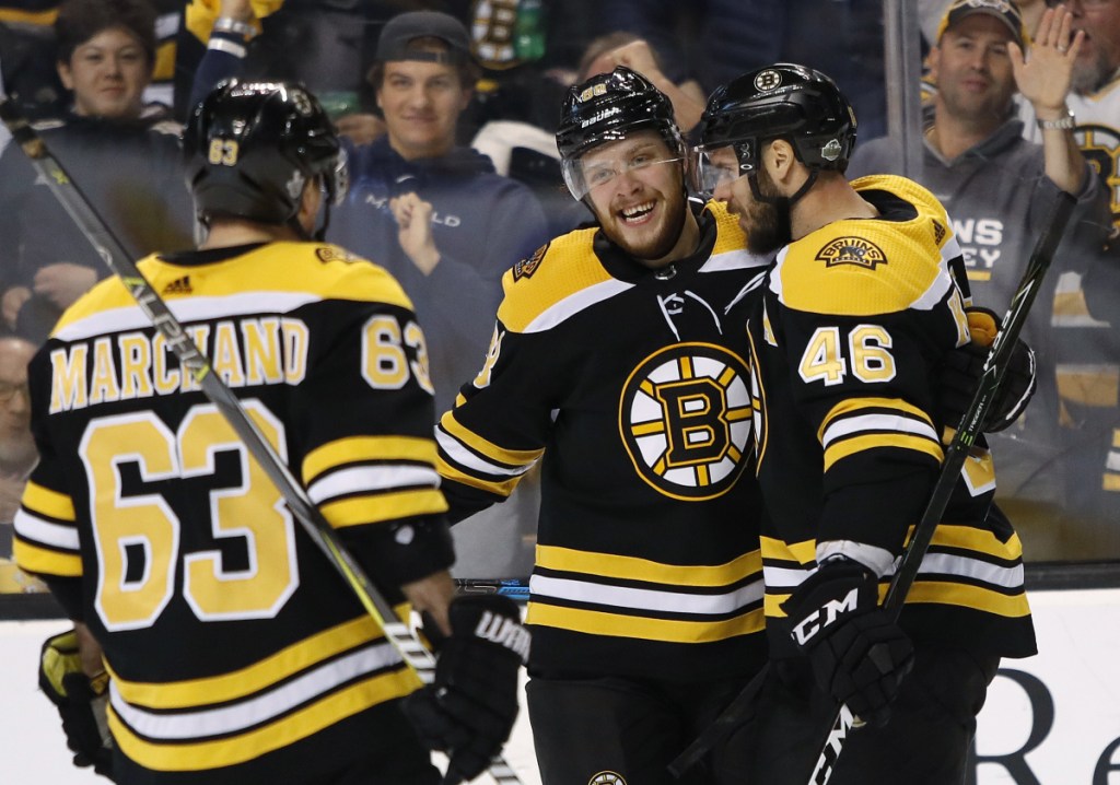 David Pastrnak, center, celebrates with Bruins teammates Brad Marchand, left, and David Krejci after a goal by Krejci in the second period Saturday night against the Toronto Maple Leafs. Pastrnak finished with three goals and three assists as Boston won 7-3 to take a 2-0 lead in the best-of-seven playoff series.
