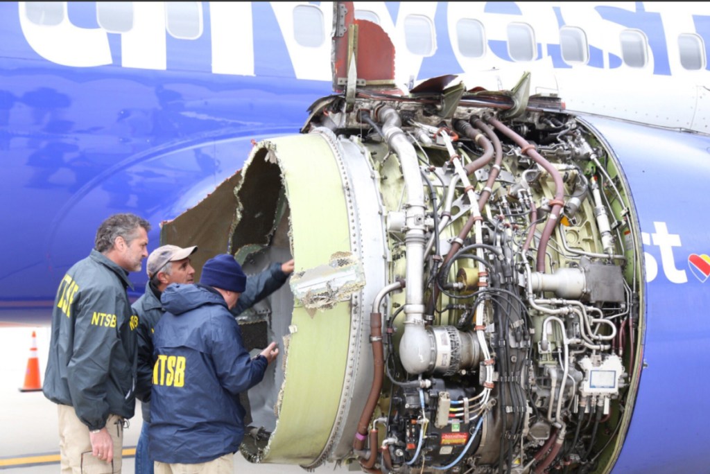 National Transportation Safety Board investigators examine damage to the engine of the Southwest Airlines plane that made an emergency landing in Philadelphia on Tuesday.