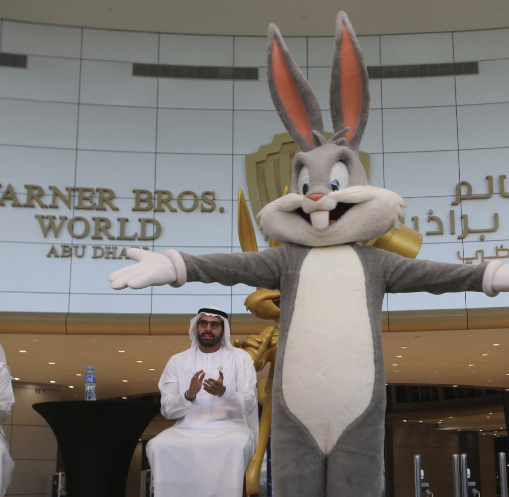 Mohamed Khalifa al-Mubarak, the chairman of both Miral and Abu Dhabi's Department of Culture and Tourism, claps for a Bugs Bunny character during a news conference in Abu Dhabi, United Arab Emirates, on Wednesday organized by the Warner Bros. World amusement park opening in July.