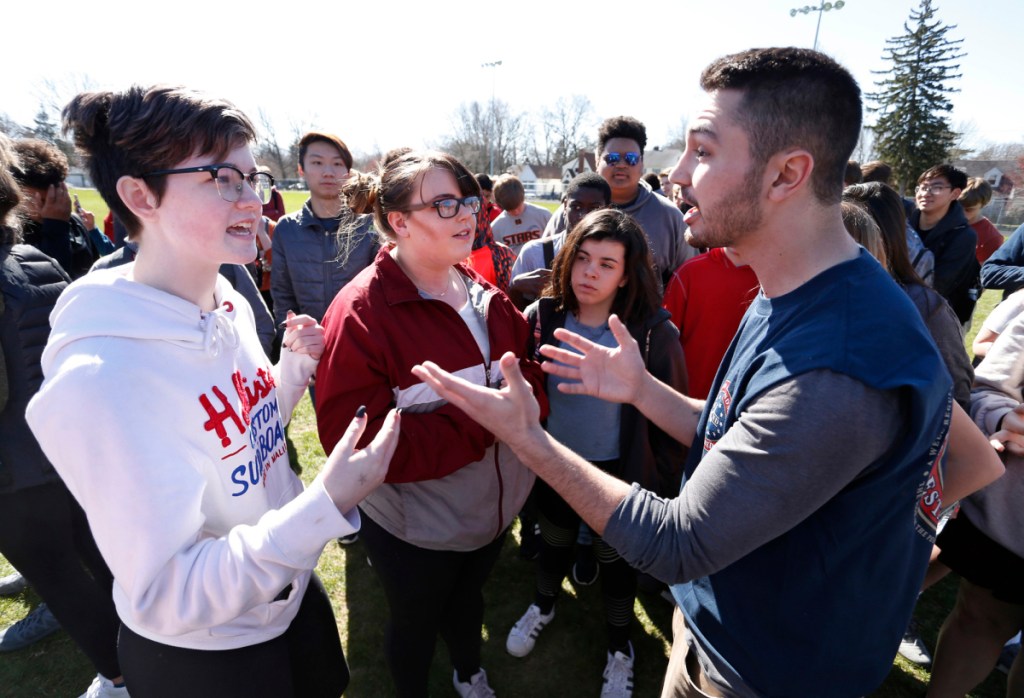 Elaine Flores, left, and Jared Baumann engage in a debate about gun control following the school walkout to protest gun violence Friday at West Lafayette High School in West Lafayette, Ind.