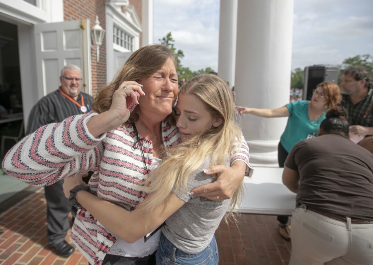Judge Sarah Ritterhoff Williams embraces student Attie French, a family friend, after finding her in the crowd at First Baptist Church while looking for her own daughter following a shooting at Forest High School on Friday in Ocala, Fla.