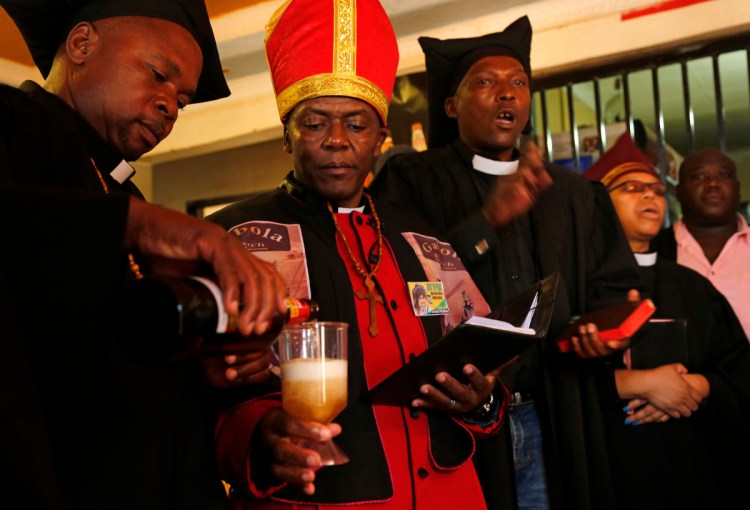 Self-proclaimed Pope Tsietsi Makiti, second left, prepares to baptize newcomers to this church.