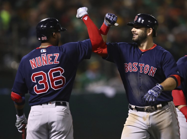 Boston's Mitch Moreland, right, celebrates with Eduardo Nunez after hitting a grand slam in the sixth inning at Oakland on Friday night. (AP Photo/Ben Margot)