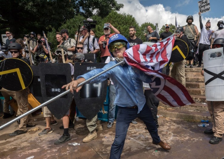 William Fears, center holding the flag, is pictured with other white supremacists at a Unite the Right rally in Charlottesville in August. The loose collection of white supremacist groups known as the alt-right movement has suffered significant setbacks since then.