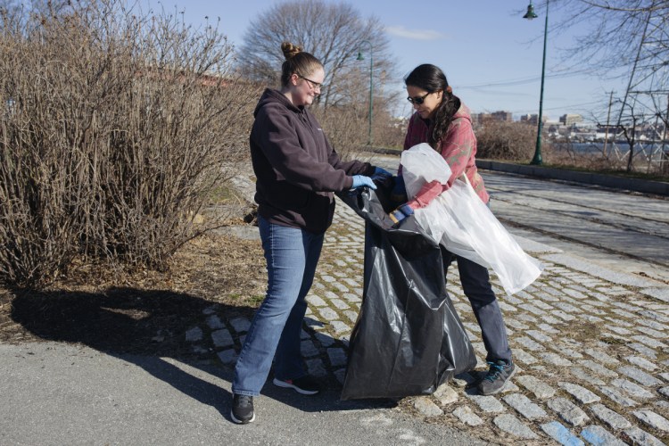 SOUTH PORTLAND, ME - APRIL 21: From left, Nicole Malpass, of Gorham, and Christine Bodnar, of Standish pick up litter at Thomas Knight Park. Both women are members of the Coast Guard and work in South Portland. The city-wide litter clean up in celebration of Earth Day was organized by the South Portland Land Trust Program.