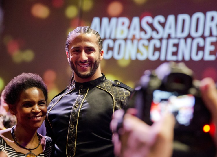Former NFL quarterback Colin Kaepernick poses with guests after wining the Amnesty International Ambassador of Conscience Award for 2018 in Amsterdam on Saturday.