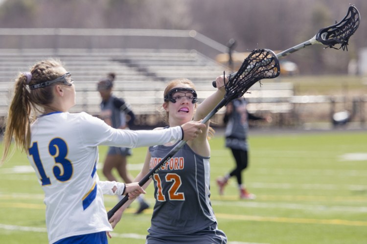 Biddeford's Jillian Lewis, right, tries to block a pass from Falmouth's Christina Oakes in the first half of Saturday's game. Falmouth opened an 11-2 lead and held on for an 11-8 victory in its first game of the season.