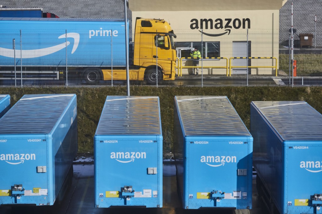 A truck pulling an Amazon Prime branded cargo container waits beside the entrance gate at an Amazon.com Inc. fulfillment center.