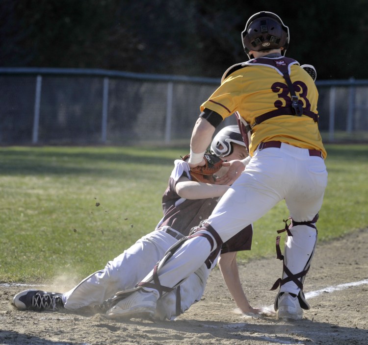 Cape Elizabeth catcher Brendan Tinsman tags out Connor Sullivan of Greely on a throw from center fielder Jameson Bakke during the third inning Monday. The Capers went on to a 4-1 victory in 13 innings at Cumberland.