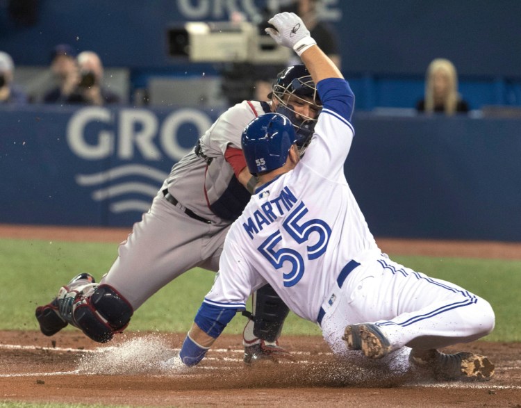 Red Sox catcher Sandy Leon tags out Toronto's Russell Martin at the plate in the second inning Tuesday at Toronto. The Blue Jays beat the Sox 4-3 in 10 innings.