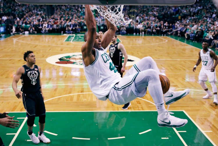 Boston Celtics forward Al Horford hangs from the rim after dunking against the Milwaukee Bucks during the first quarter of Game 5 of an NBA basketball first-round playoff series in Boston, Tuesday, April 24, 2018. (
