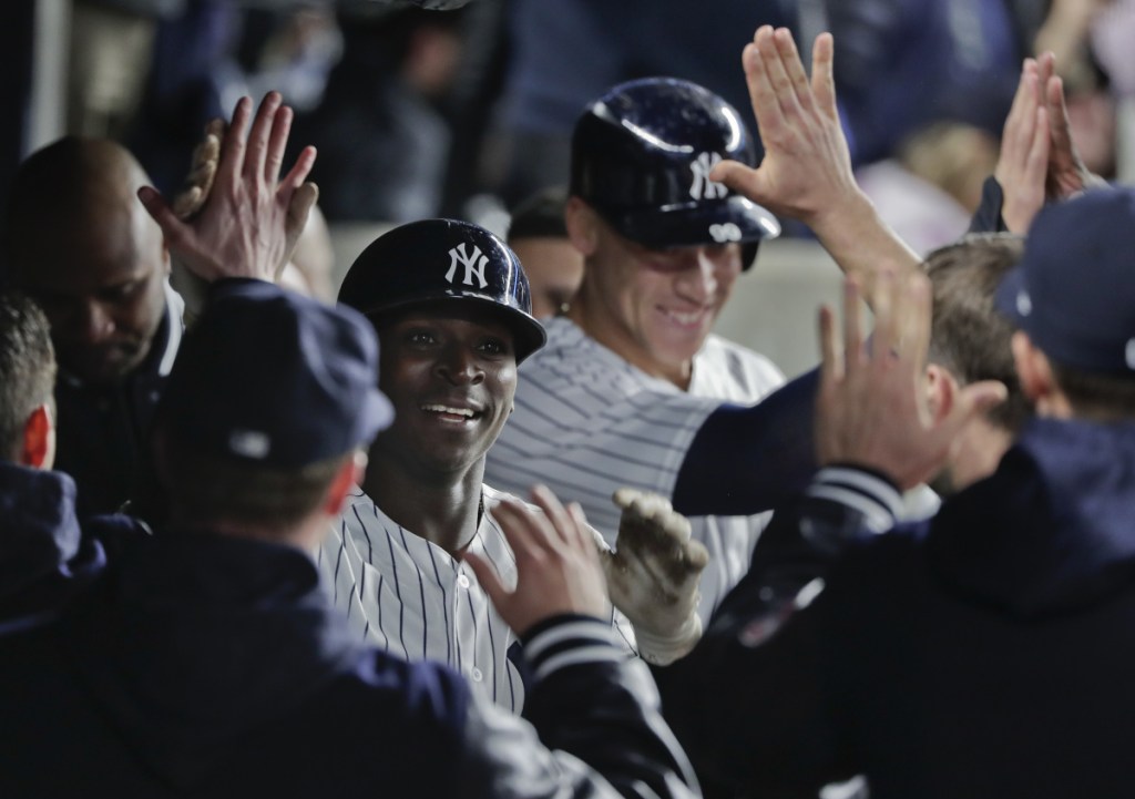 The Yankees' Didi Gregorius, center left, is congratulated by teammates in the dugout after driving in Aaron Judge, center right, with a two-run homer against the Twins on Tuesday night.