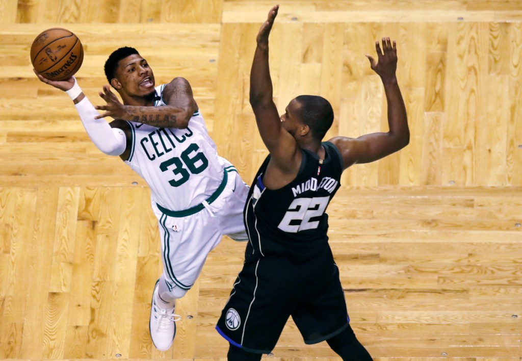 Boston guard Marcus Smart (36) is fouled by Milwaukee forward Khris Middleton (22) on a drive to the basket during the second half of Game 5 of a first-round playoff series Tuesday in Boston.