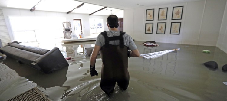 Gaston Kirby walks through floodwater inside his home last September in the aftermath of Hurricane Harvey, which sent the Addicks and Barker reservoirs over their banks in Houston.