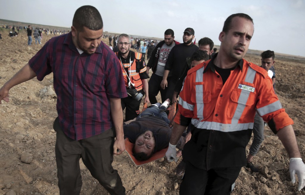 Palestinian medics carry a wounded man during a protest at the Gaza Strip's border with Israel on Friday.