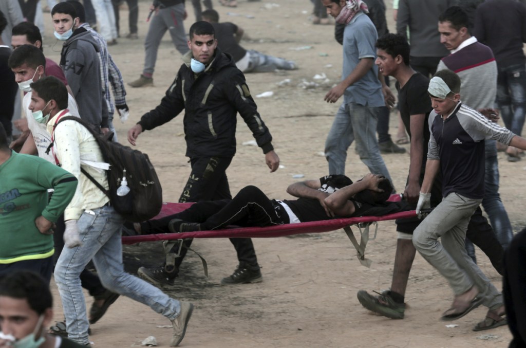 Palestinian protesters evacuate a youth during a protest at the Gaza Strip's border with Israel, east of Khan Younis, on Friday. Palestinians converged on the Gaza border with Israel for a fifth round of weekly protests Friday.