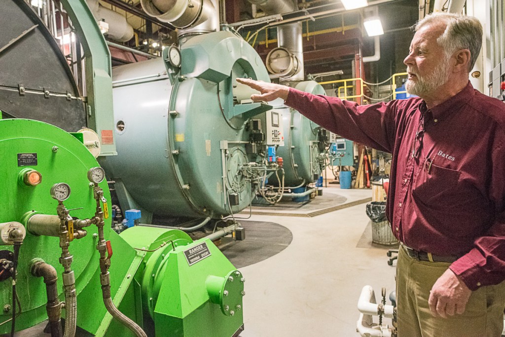 John Rasmussen, energy manager at Bates College, points to a new burner on an old boiler in the Cullen Maintenance Center on Wednesday afternoon. The college burned 780,000 of renewable, plant-based fuel oil to heat much of the campus this winter.