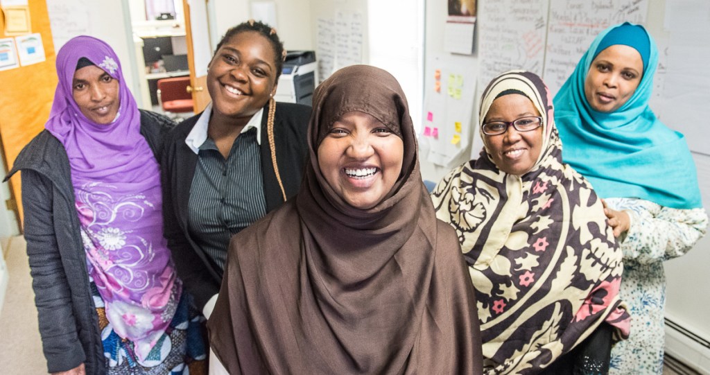 Fatuma Hussein, center, stands with co-workers at the Immigrant Resource Center of Maine on Lisbon Street in Lewiston. From left: Amina Farah, Bright Musuamba, Hussein, Zahra Houssein and Choukri Mohamed.