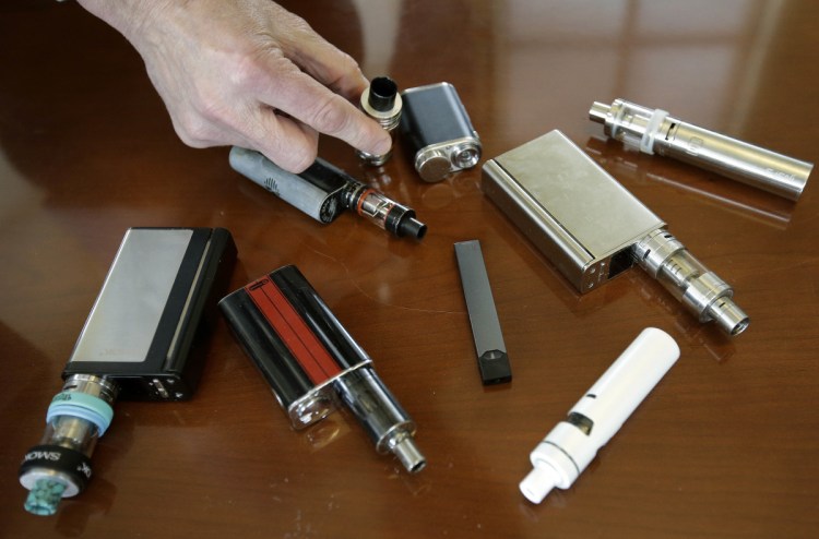 Marshfield (Mass.) High School Principal Robert Keuther displays vaping devices that were confiscated from students in places such as restrooms or hallways at the school. Associated Press/Steven Senne