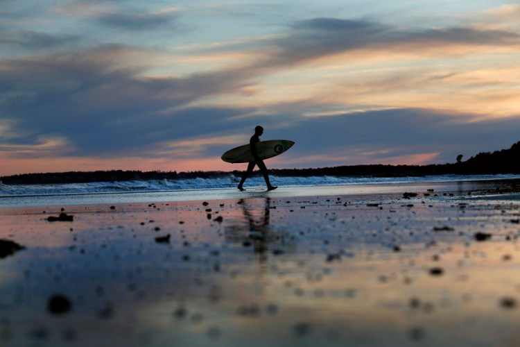 Chris Pickles of Scarborough walks along Higgins Beach after surfing in March, 2017. 