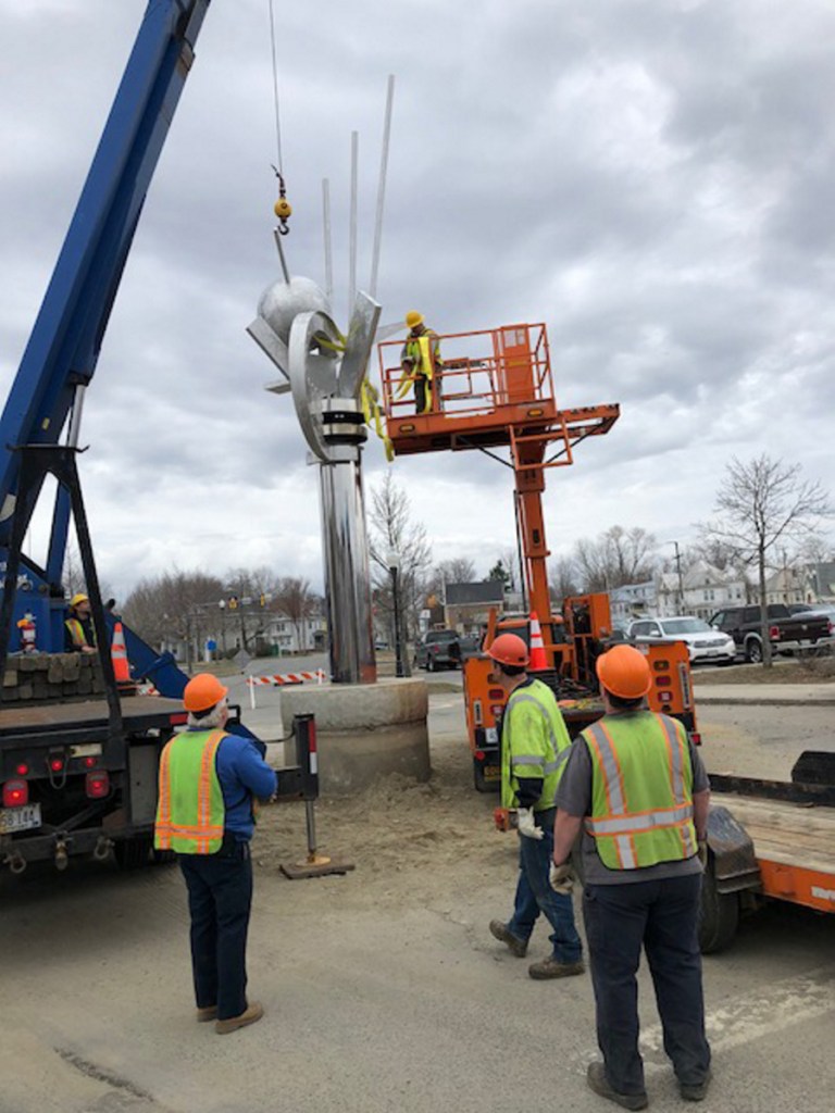 Employees of The Cote Corp. and the Waterville Public Works Department prepare to remove the top part of "The Ticonic" sculpture Wednesday morning on The Concourse in Waterville. In the bucket is public works facility maintenance technician Mike Folsom.