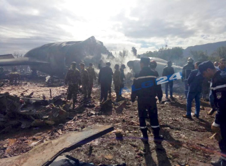 This image posted by Algerian news agency ALG24 shows firefighters and soldiers at the scene of the fatal plane crash near Boufarik military base near the Algerian capital, Algiers. 