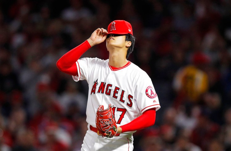 Shohei Ohtani adjusts his hat during the second inning in Anaheim. His impressive opening month has drawn unprecedented early season attention and Tuesday night's home crowd was the Angels' second-biggest since the year 2000. 