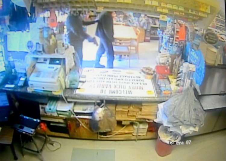 An image taken from surveillance video Wednesday at the Moby Dick Variety Store in Old Orchard Beach shows the robber with a gun at the back of Ilias Sigkas, who was confronted while smoking outside and forced to enter the business. “I was scared,” Sigkas said.