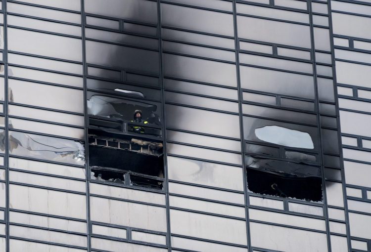 A firefighter looks out from the window of a fire-damaged apartment in Trump Tower in New York on Saturday. The Fire Department said the blaze broke out on the 50th floor shortly before 6 p.m. 