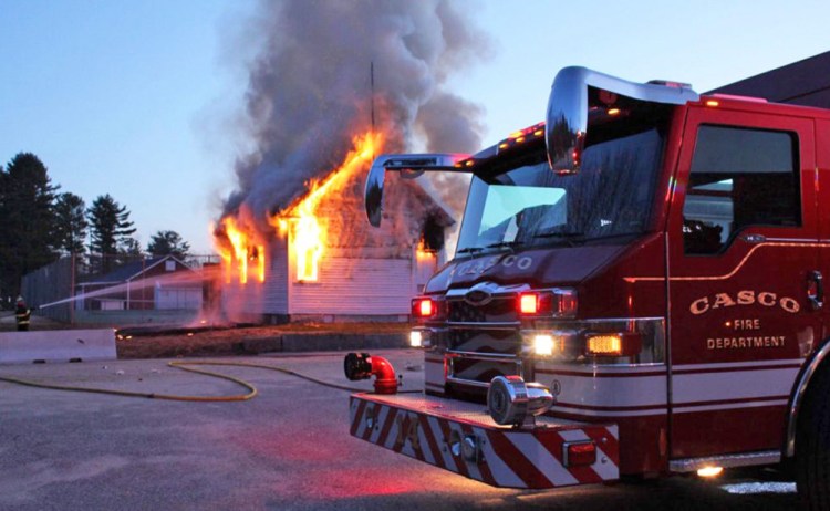 Firefighters battle the blaze at the Friends School House in Casco on Sunday. 