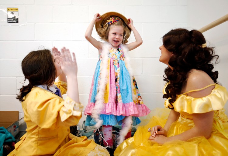 Katie Creedon, 6, of Buxton, who has CDKL5 deficiency, a rare disease that affects fewer than 1,000 people in the world -- plays with a costume pith helmet during her surprise birthday party on Saturday at Atlantic Dance Arts studio in Gorham. Shortly after Creedon arrived, 9 "princess" streamed into the room to play with Creedon and other children in attendance. At left, is Samantha Roche, dressed as Tarzan's love interest Jane, and Ashley Talyor, right, is dressed as Belle from Beauty and the Beast. Staff photo by Ben McCanna
