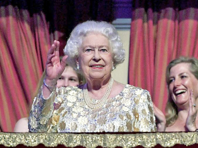 Queen Elizabeth II, surrounded by members of the royal family, waves to the crowd at the Royal Albert Hall in London on Saturday. 