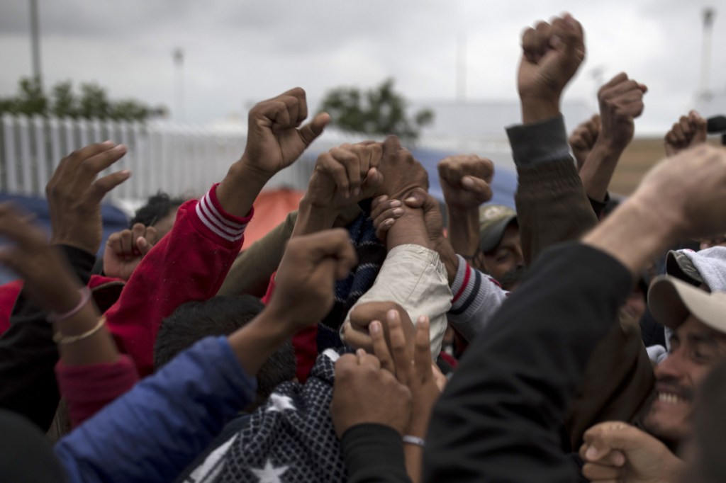 Associated Press/Hans-Maximo Musielik
Migrants cheer and celebrate after hearing the news U.S. border inspectors allowed some of the Central American asylum-seekers to enter the country for processing, in Tijuana, Mexico, on Monday, ending a brief impasse over lack of space.